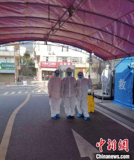 在難得的工作間隙，謝華寶和同事們身著防護服合影。供圖