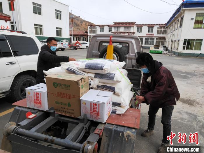 甘孜縣工作人員為村民領取分派的物資。　劉炳科 攝