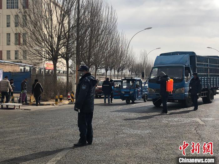 圖為青藏高原農副產品集散中心3號門口，工作人員正對進入市場車輛進行消殺。　羅云鵬 攝