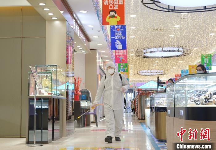 圖為工作人員在商場內消毒。　劉文華 攝