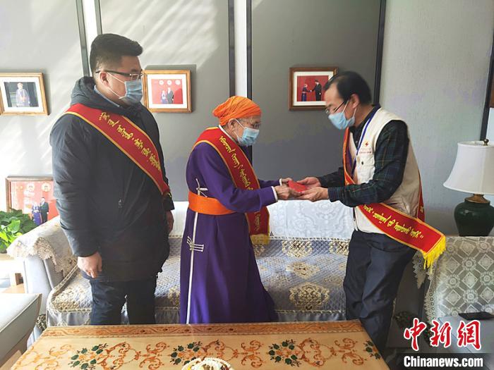 圖為“人民楷模”都貴瑪(中)為防控疫情捐款。　塔娜 攝