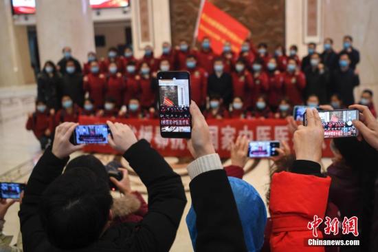 2月21日，長沙，眾人拿出手機(jī)拍攝出征的醫(yī)護(hù)人員。當(dāng)日，由湖南省中醫(yī)藥管理局組建的第五批國家中醫(yī)醫(yī)療隊(duì)出征湖北，醫(yī)療隊(duì)共有成員35人，將增援武漢江夏方艙醫(yī)院。中新社記者 楊華峰 攝